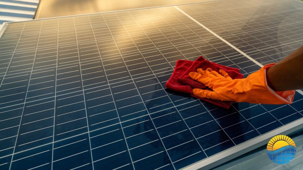 a person cleaning a solar panel with an orange glove